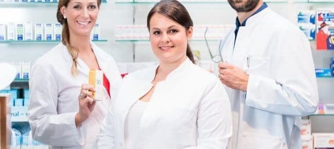 three pharmacy students smiling at camera