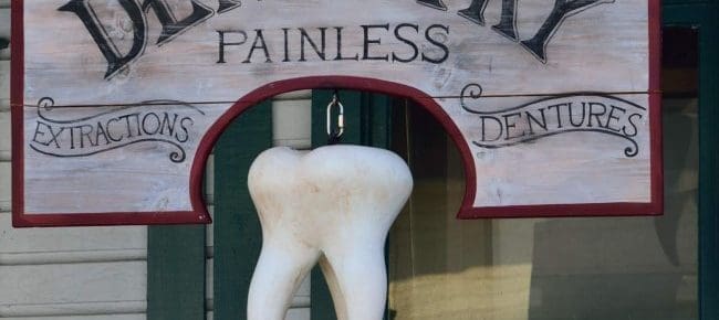 dentist wood sign with hanging tooth
