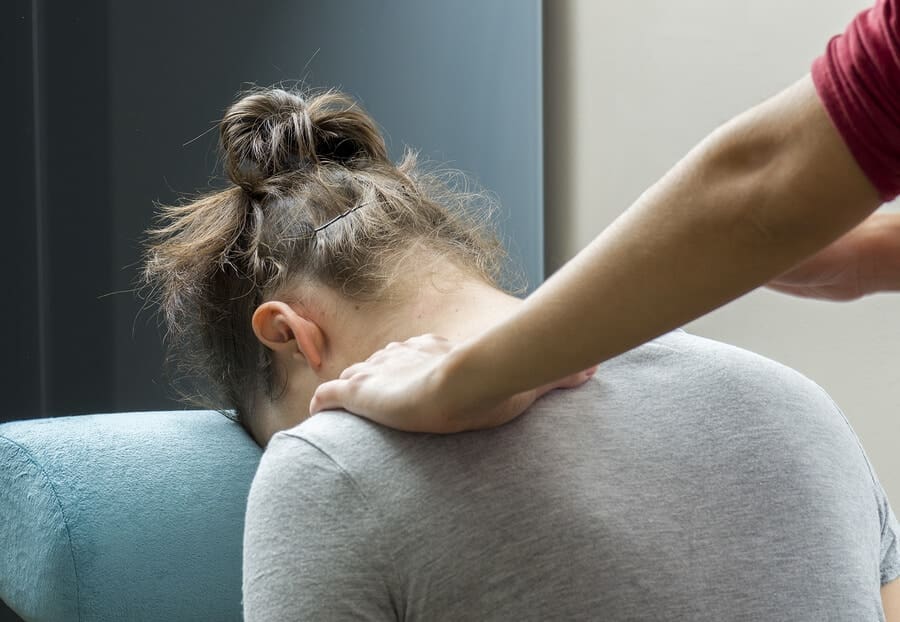 chiropractor working on female's neck