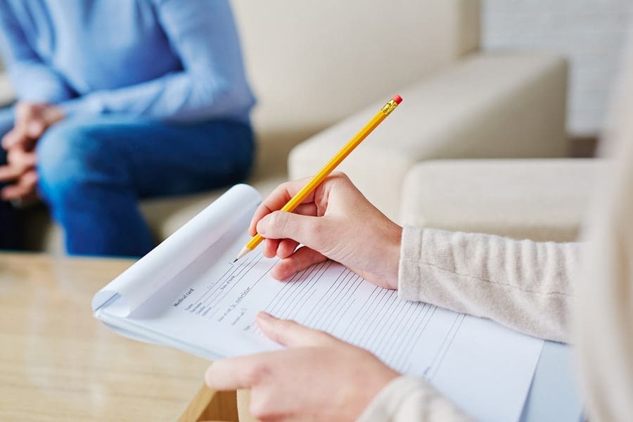 female hands filling out paperwork on clipboard