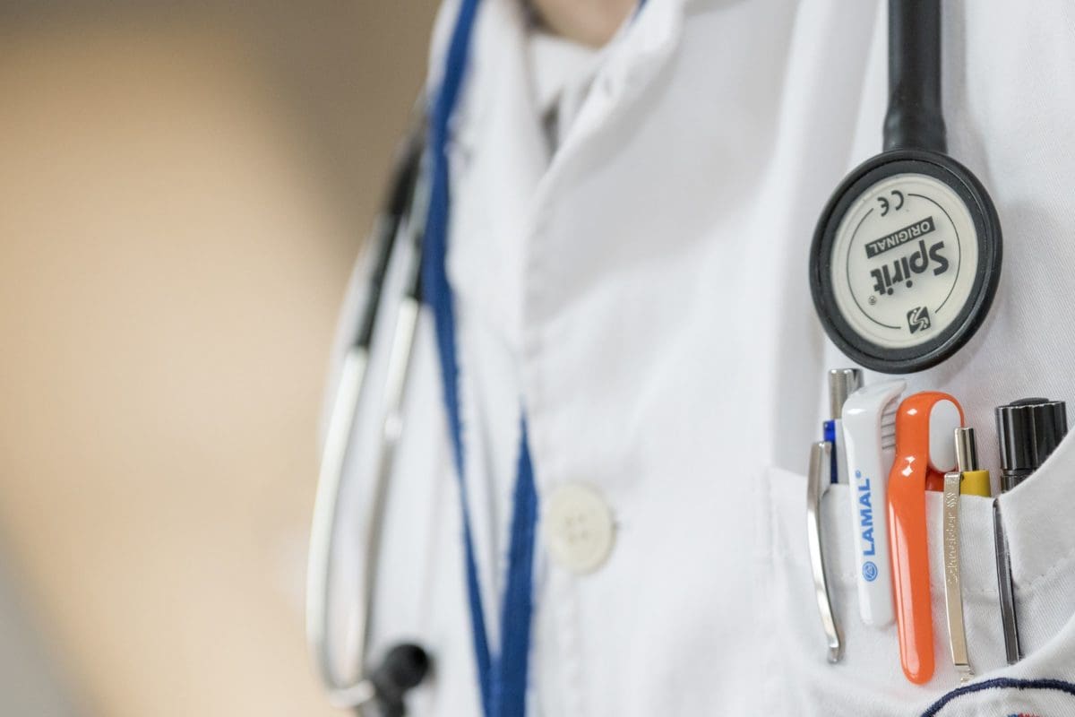 male chest in lab coat with pencils and stethoscope