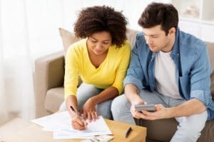young couple doing paperwork with calculator