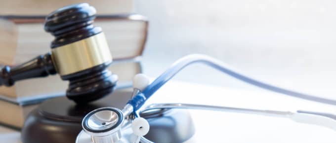 stethoscope, gavel and books on desk