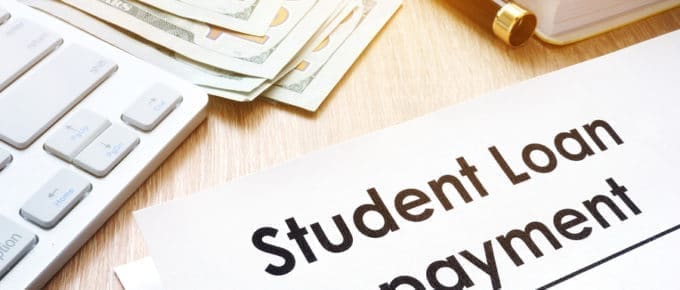 student loan repayment document with calculator and $100 bills