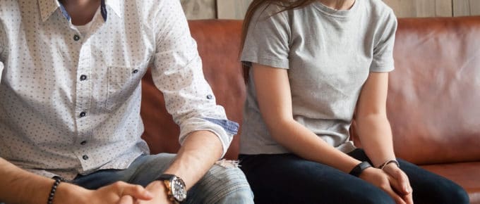 faceless young male and female couple on couch