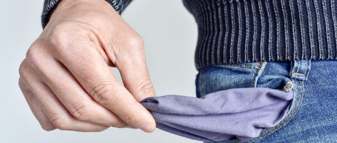 mid section of male holding an empty pocket of his jeans