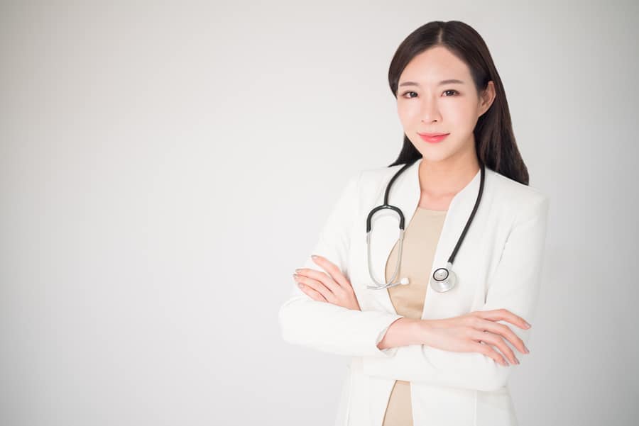 asian Dr with lab coat and stethoscope folding arms