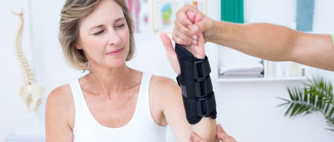 PT hands working on female patients wrist in brace