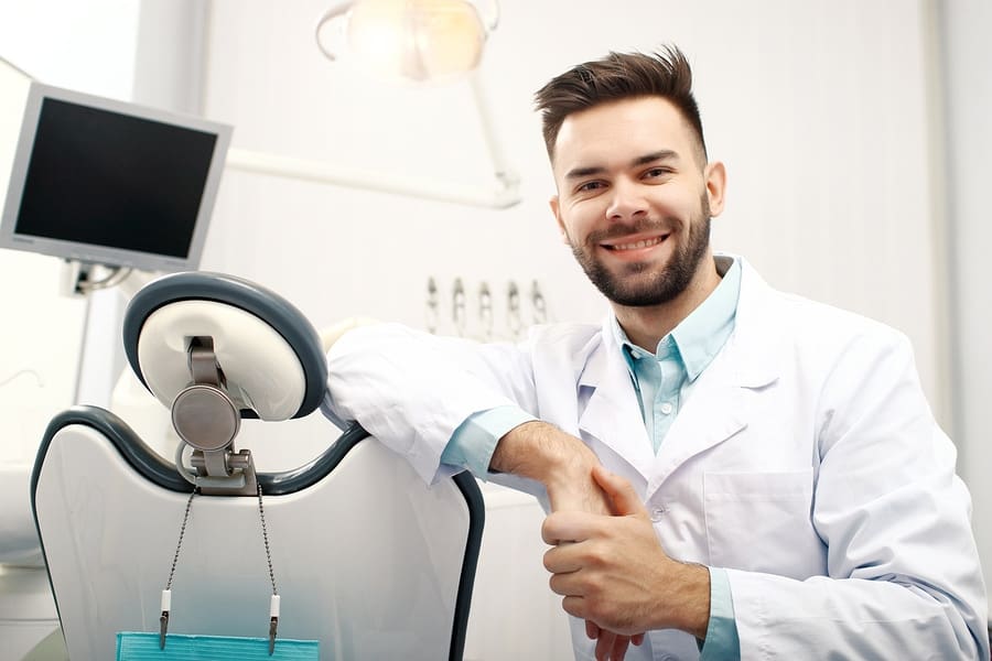 Dentist leaning on a dental chair in dental room