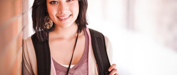 college student leaning against wall