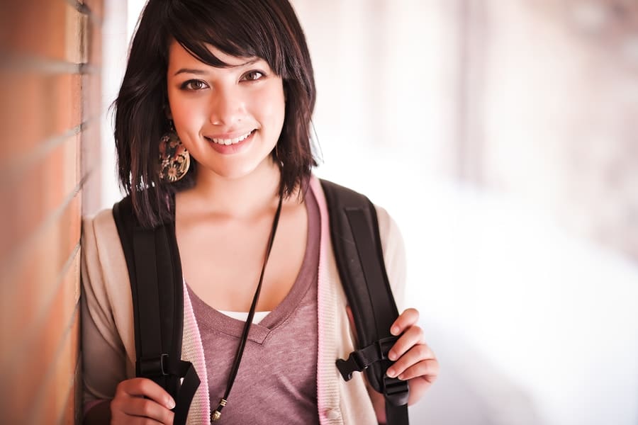 college student leaning against wall