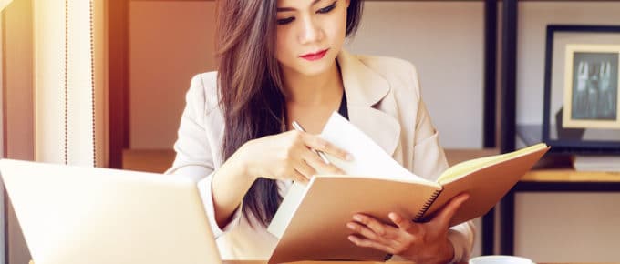 young female professional with notebook and laptop