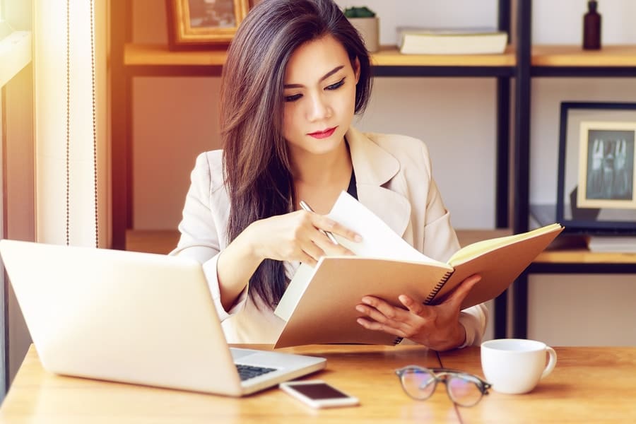 young female professional with notebook and laptop