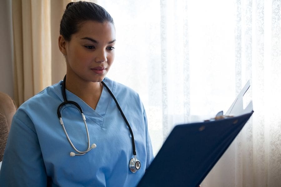 young nurse looking at clipboard