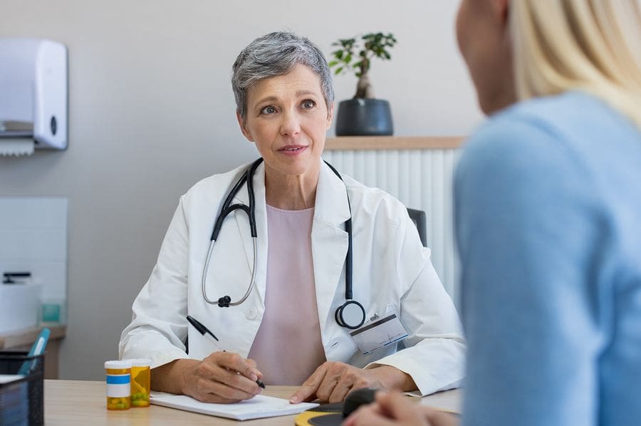 Female Dr at desk speaking with female patient