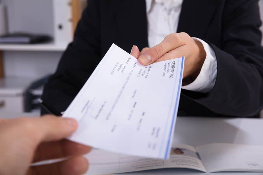 faceless female hand giving a check to someone's hand