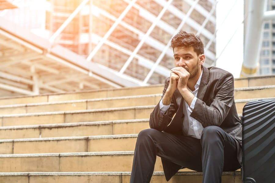 male in suite and folded hands frustrated