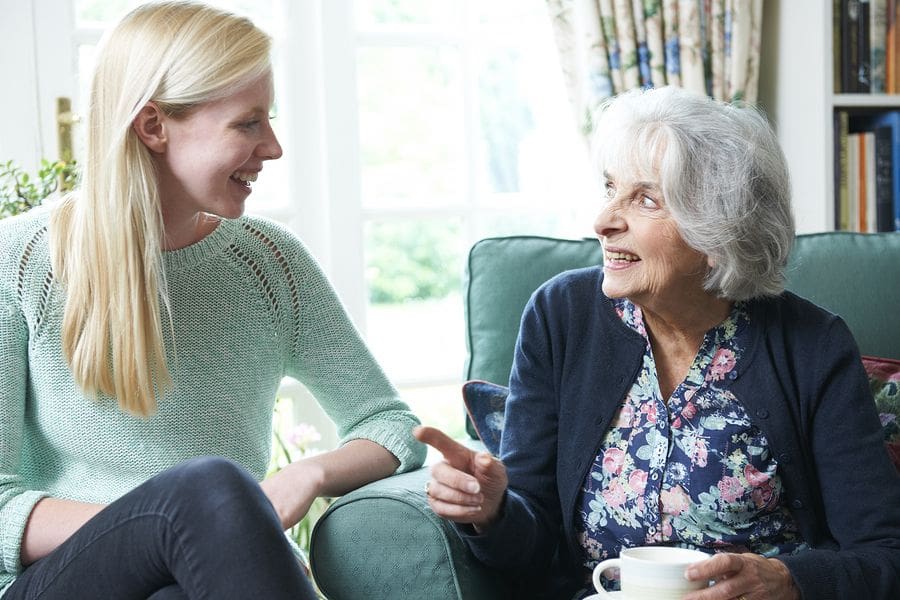 grandma with coffee speaking with granddaughter