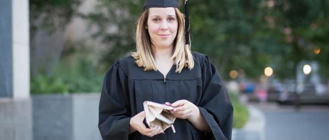 young female in grad regalia with empty wallet