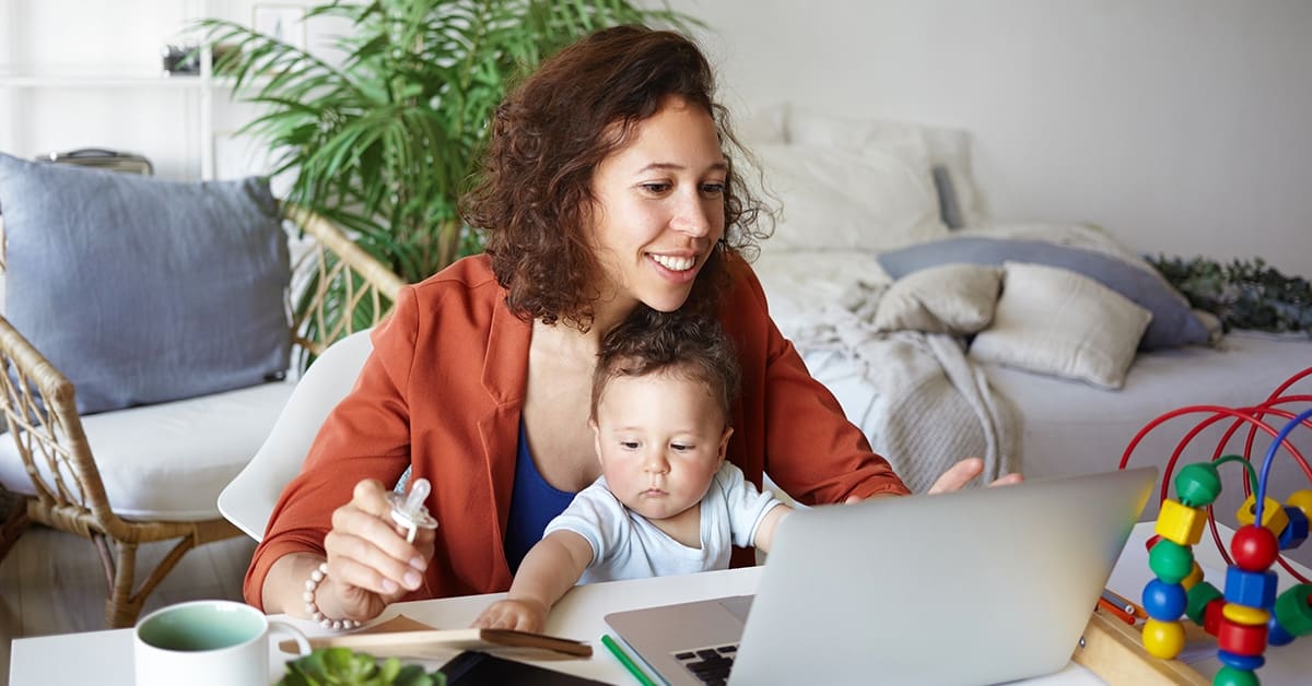 young-woman-working-laptop-baby-sitting-lap