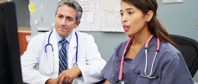 male dr and female nurse looking at a computer