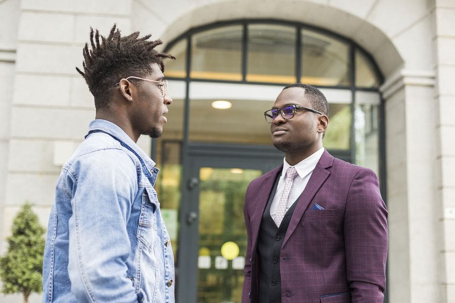 two young black men speaking outside library