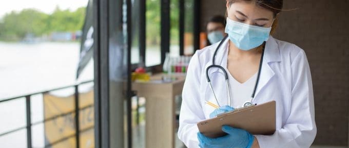 female resident working on clipboard with face mask