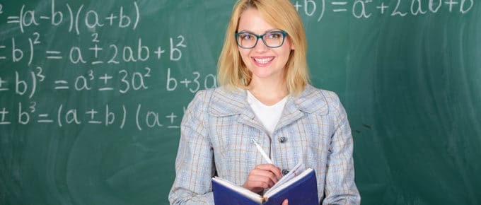 female teacher smiling blackboard
