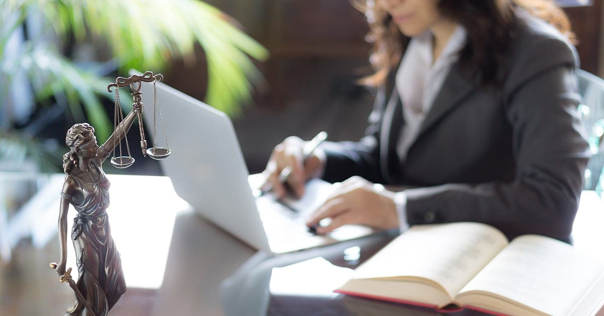 female lawyer at desk with law statue