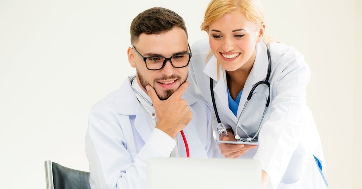 male and female doctors working on laptop