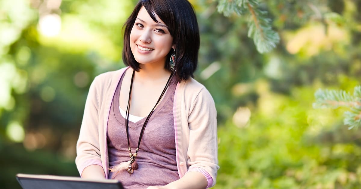 female college student smiling with laptop
