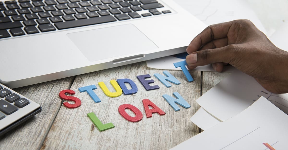 hand arranges letters to spell student loans