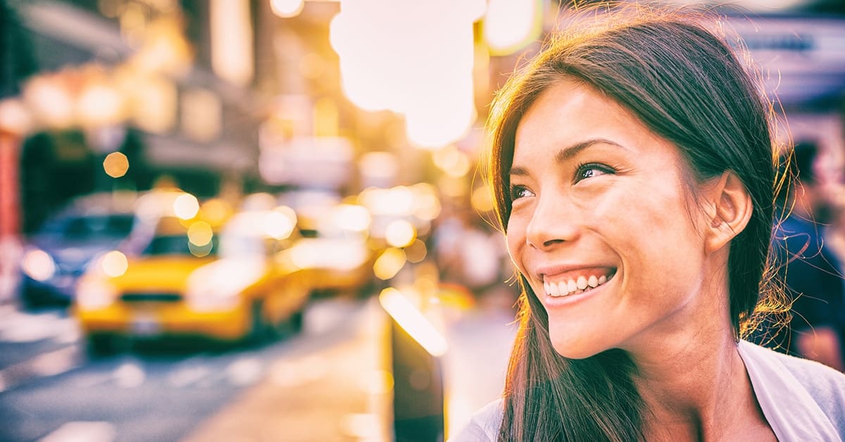 woman smiling new york with taxis in background