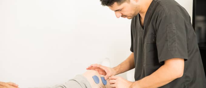male physical therapist works with patient