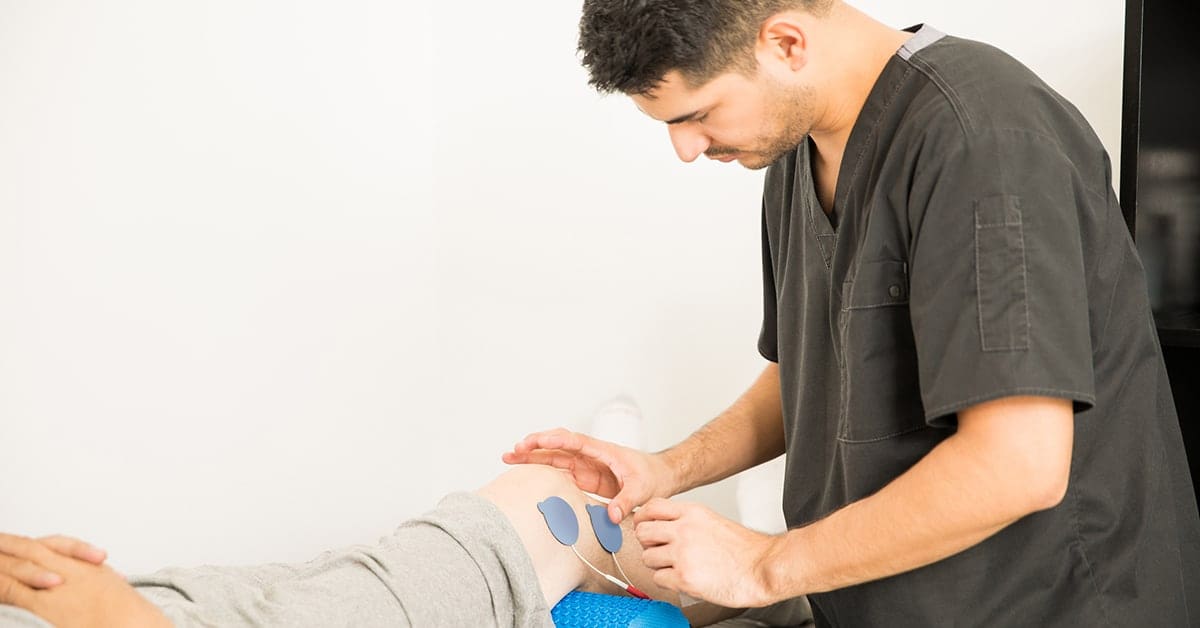 male physical therapist works with patient