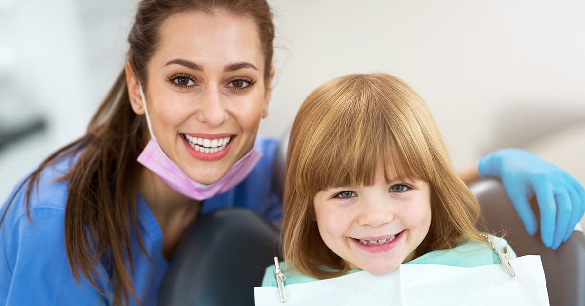 female-dental-hygienist-smiling-child-patient