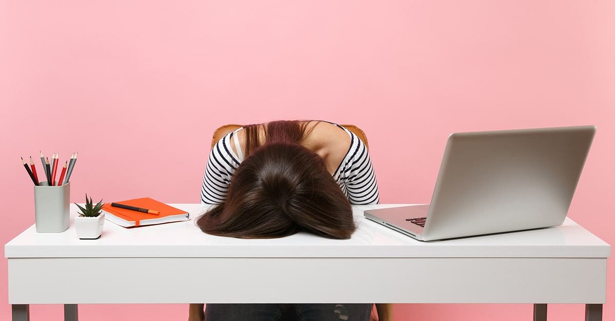 frustrated-young-woman-head-on-desk