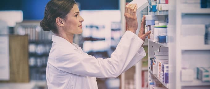 woman-pharmacist-putting-medicine-shelf