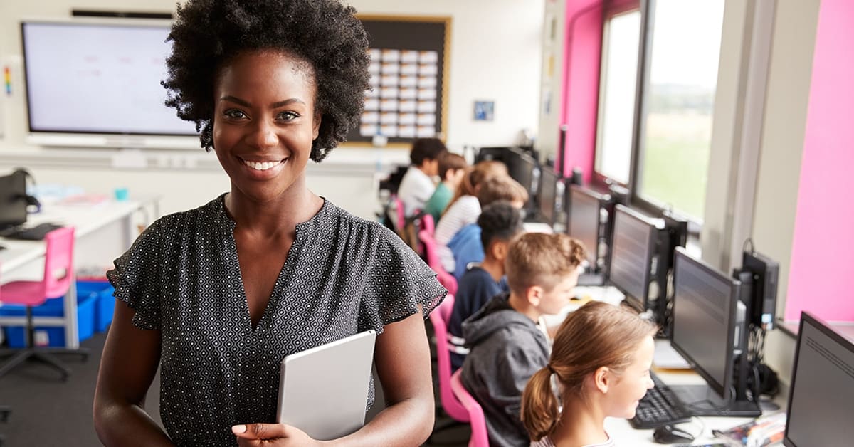 young-female-teacher-smiling-high-school-students-computers