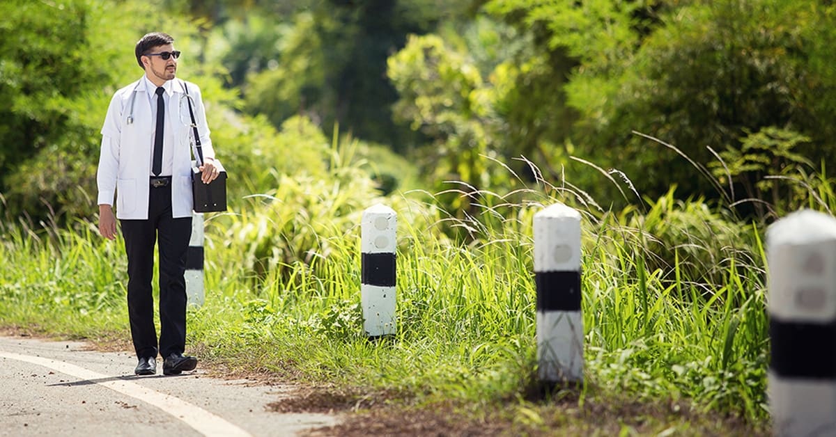 male-doctor-walking-side-rural-road