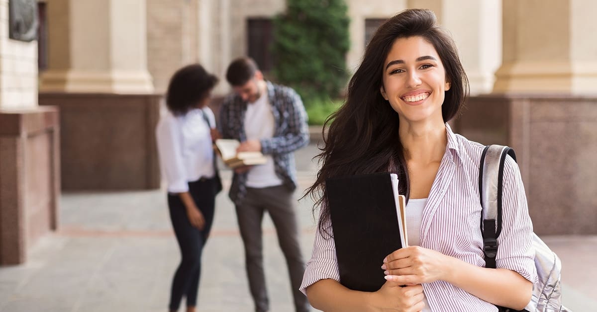 smiling-female-college-student-foreground-two-other-students-background