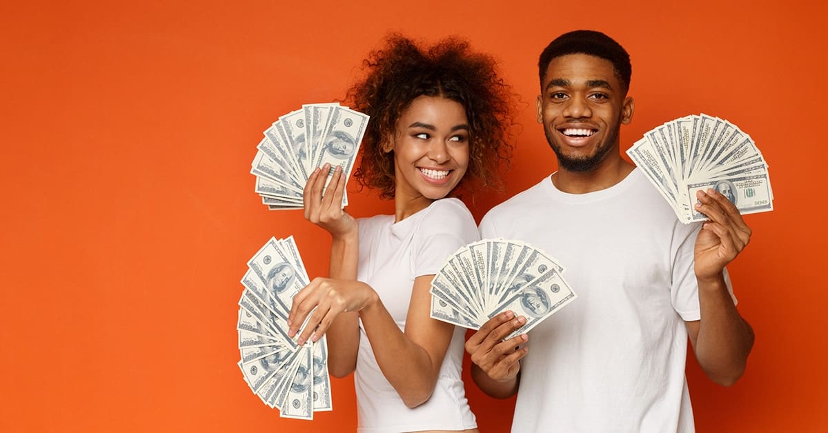 excited-young-couple-holding-money-fans