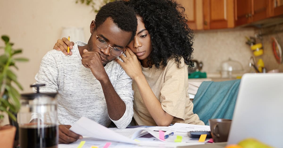 stressed-couple-examining-finances-bills