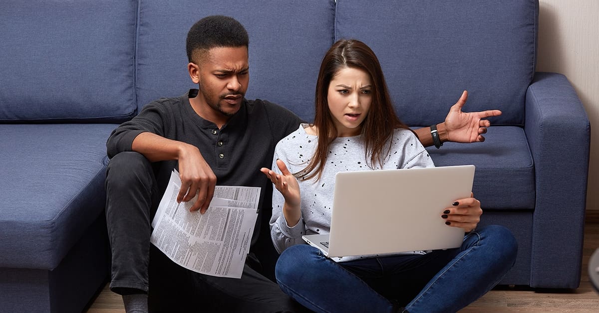 confused-man-woman-couple-examining-laptop