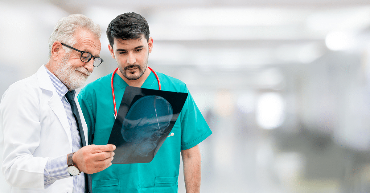 older-male-doctor-with-younger-male-doctor-examining-patient-xray