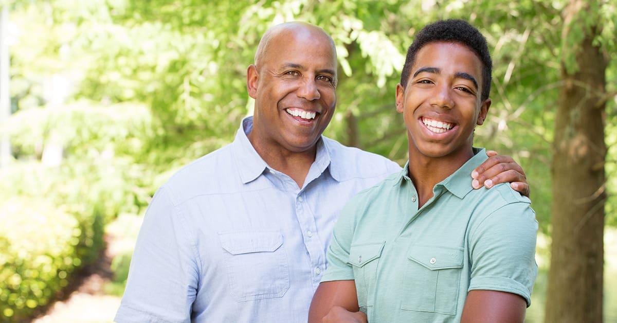 father-teenage-son-smiling-arm-around-son