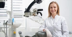 young-female-dentist-leaning-dental-equipment