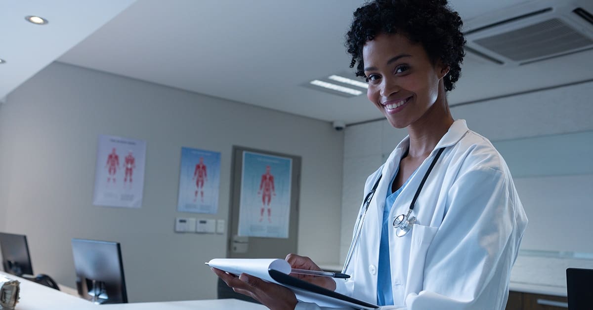 young-female-doctor-writing-clipboard-smiling