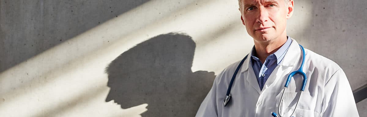 senior-doctor-outside-concrete-wall
