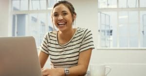 Woman Laughing While on Laptop